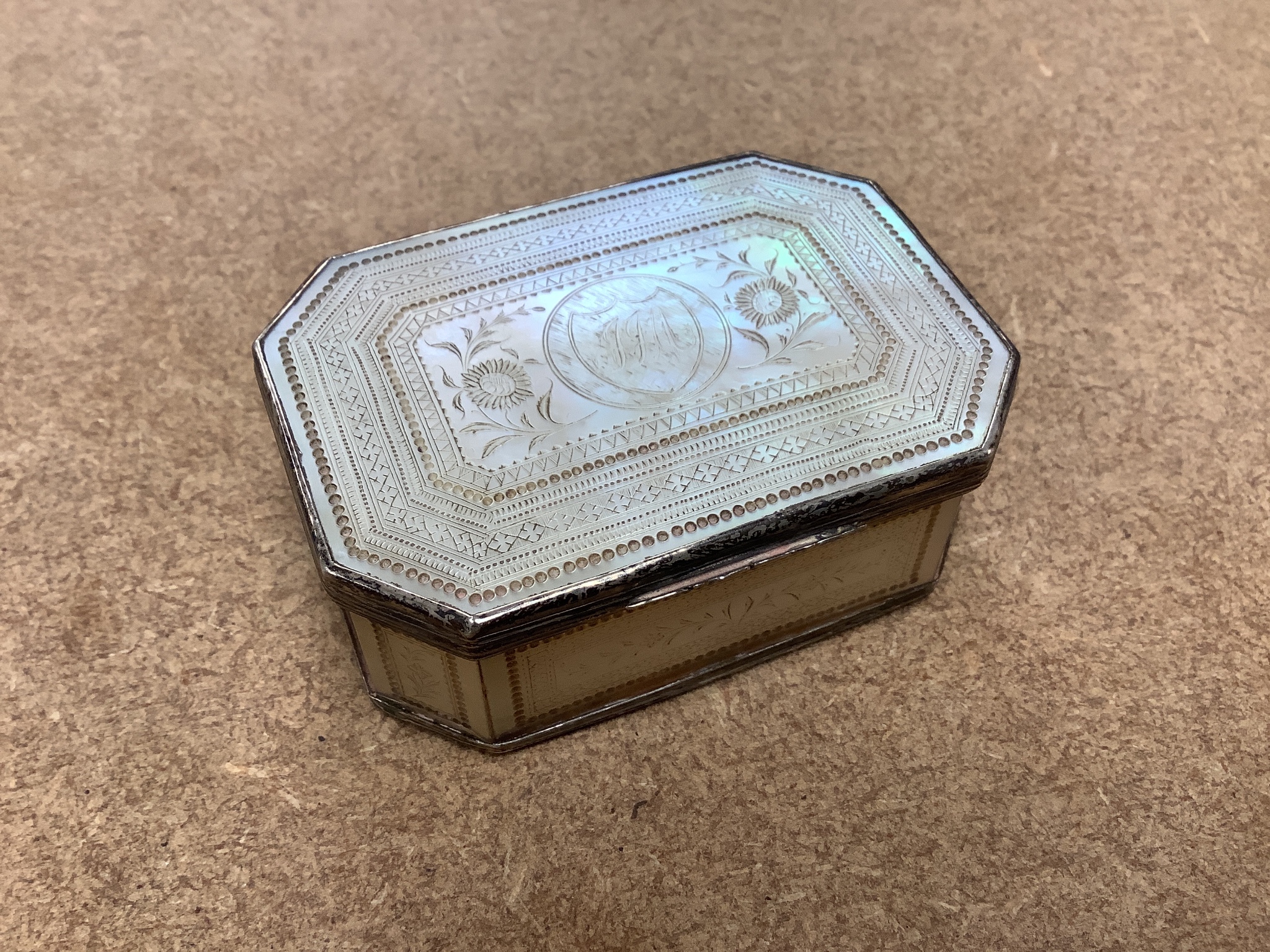 A 19th century panelled mother of pearl box together with a Chinese carved peach stone, a Chinese ivory bangle and a small worked bone multi-tool